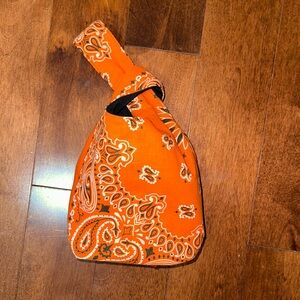 Yaito LLC Paisley knot bag in orange.